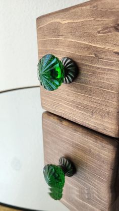 two wooden drawers with green glass knobs on them