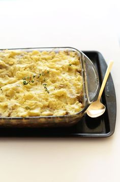 a casserole dish on a tray with a spoon