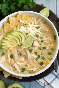 a bowl of chicken tortilla soup with avocado and cheese