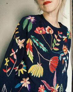 a woman with blonde hair wearing a blue sweater and red lipstick is posing for the camera