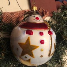 a glass ornament with a snowman on it's face and stars