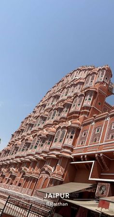 a tall building with many balconies on the top and bottom floors in india