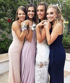 four beautiful young women standing next to each other posing for the camera with their hands together