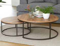 two coffee tables sitting on top of a rug in front of a couch and chair