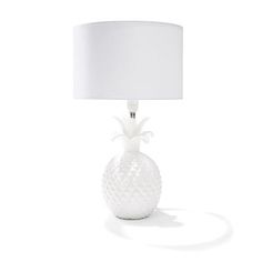 a white pineapple lamp with a white shade on the base and a white drum light