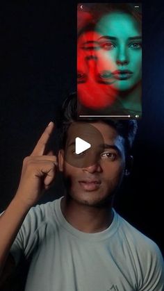 a man is holding up a photo with his face painted red, green and blue