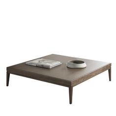 a coffee table with a book and remote control sitting on it's side, in front of a white background