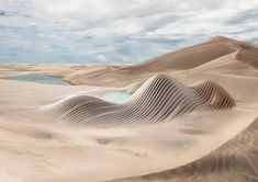 sand dunes with water and clouds in the background