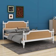 a white bed sitting on top of a hard wood floor next to a blue wall