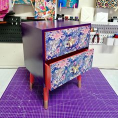 a purple and red dresser sitting on top of a purple mat