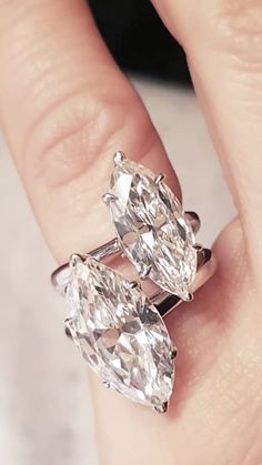 a woman's hand holding two engagement rings