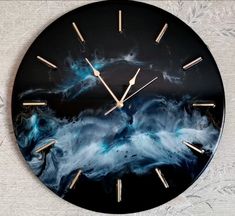 a black clock with blue and white swirls on it's face is shown