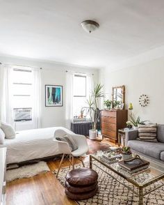 a living room filled with furniture and a large window covered in sunlight shining through the windows