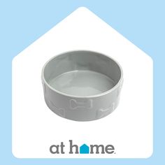 a white dog bowl sitting on top of a blue and white background with the words at home written below it