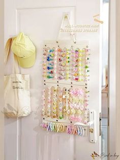 a white door with a bunch of hair clips hanging on it's side next to a bag