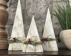 three small wooden christmas trees on a table