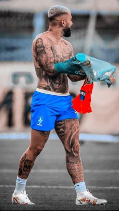 a man with tattoos holding a blue bag