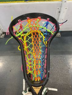 a racket with many colored strings attached to it's back end, sitting on top of a cart