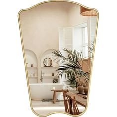 a mirror that is on the wall in front of a table with chairs and a potted plant