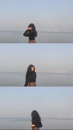 a woman standing on top of a beach next to the ocean with her head in her hands