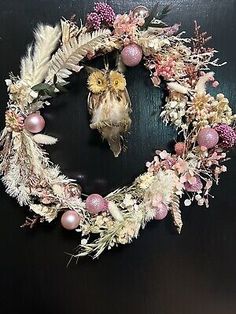 a wreath with flowers and feathers on it