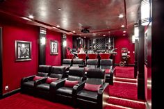 a home theater with red carpet and black leather seats