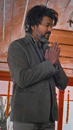 a man standing with his hands folded in prayer