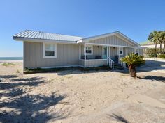 a house on the beach with palm trees