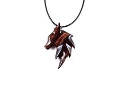 a necklace with an animal's head made out of wood on a black cord