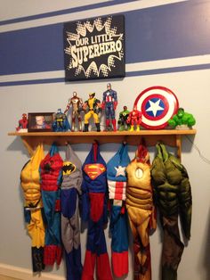 there are many superhero costumes hanging on the wall