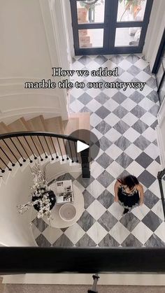 an aerial view of a woman sitting at the top of a stair case looking down