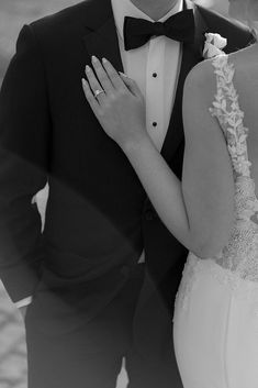 a bride and groom are posing for a wedding photo in their tuxedo attire