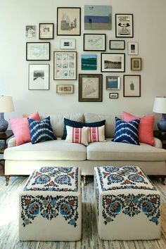 a living room filled with lots of furniture and pictures on the wall above it's couch