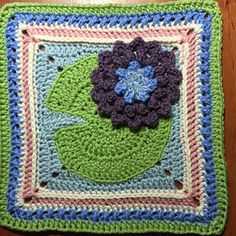 a crocheted square with a flower on it