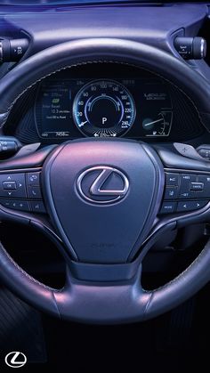 the interior of a car with steering wheel controls and dashboard gauges, including an electronic display