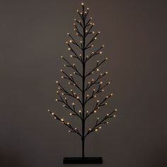 a lighted christmas tree on a black stand