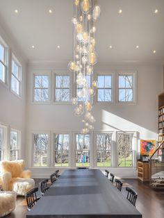 a large dining room table with chairs and a chandelier hanging from the ceiling