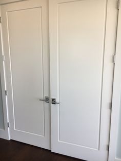 two white doors are open in an empty room