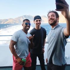 three men taking a selfie on a boat