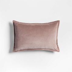 a pink velvet pillow on a white wall