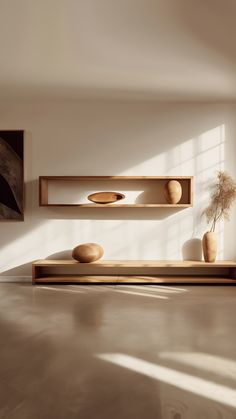 an empty room with two wooden shelves and vases