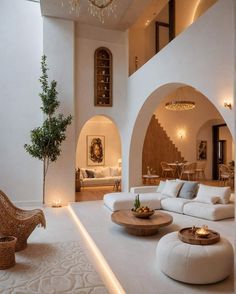 a living room filled with white furniture and a chandelier hanging from the ceiling