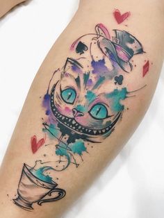 a watercolor tattoo on the leg of a woman with a cat in a cup