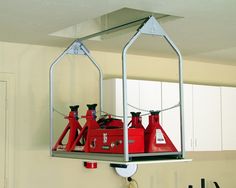 two red fire extinguishers are hanging from the ceiling in a room with white cabinets