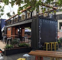 the outside of a restaurant with tables and chairs