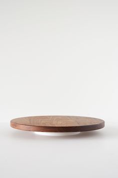 a wooden plate sitting on top of a white table