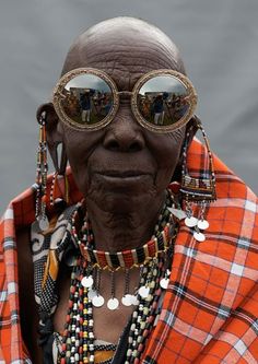 an old woman wearing sunglasses and beaded necklaces