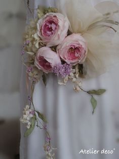 pink flowers and greenery are attached to the back of a wedding dress