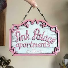 a pink sign hanging from the side of a wall