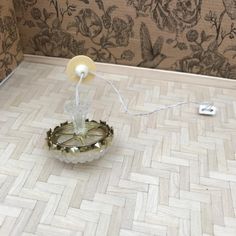 a small white flower sitting on top of a wooden table next to a wallpaper